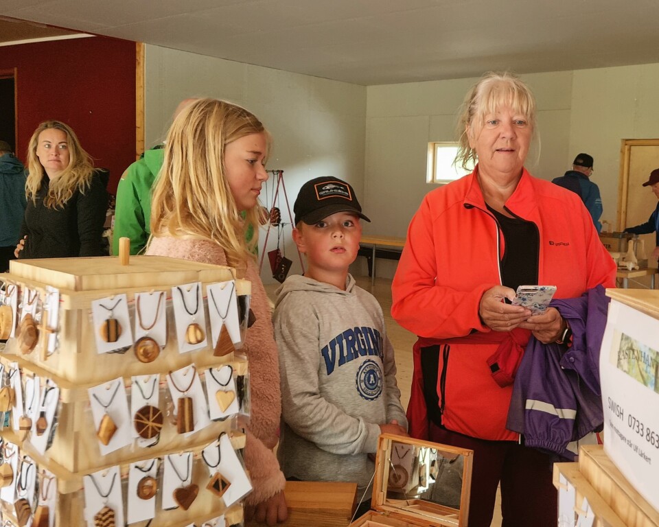 Hannes och Lova Totsås väntar medan mormor Carina Rodhe betalar ett fins träsmycke hon precis köpt.