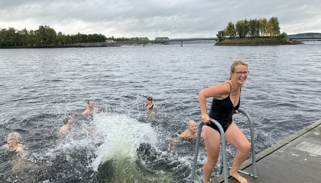 Malin Eriksson som är kassör i Storsjöns Kallbadhus tar sig ett dopp. I bakgrunden den konstgjorda ö vid vilken kallbadhuset planeras att anläggas. Foto: Privat