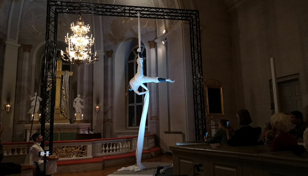 En förvånansvärt vig Sara Oja gör coola trick i höjd med Kallkyrkans kristallkrona