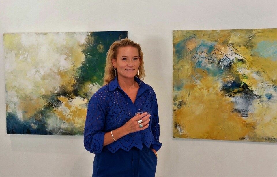 Jenny Berg vid två av sina målningar.